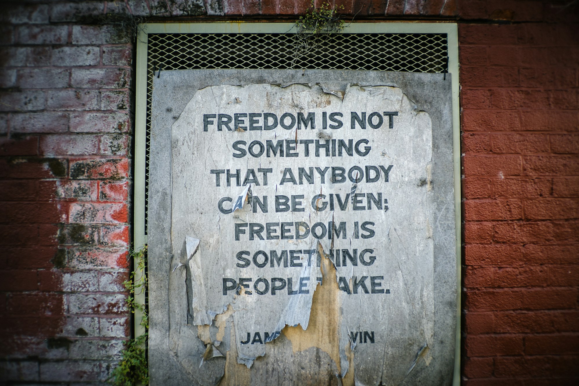 torn poster on brick wall