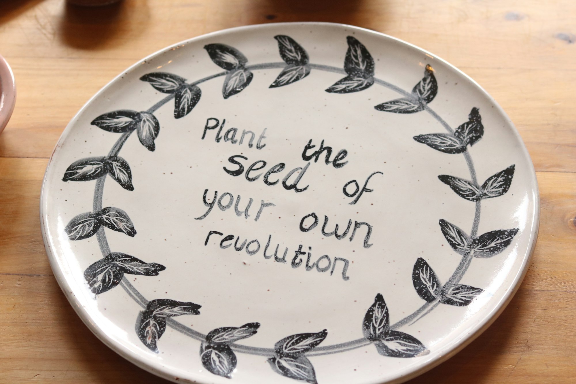 A plate with writing that says "Plant the seed of your own revolution."