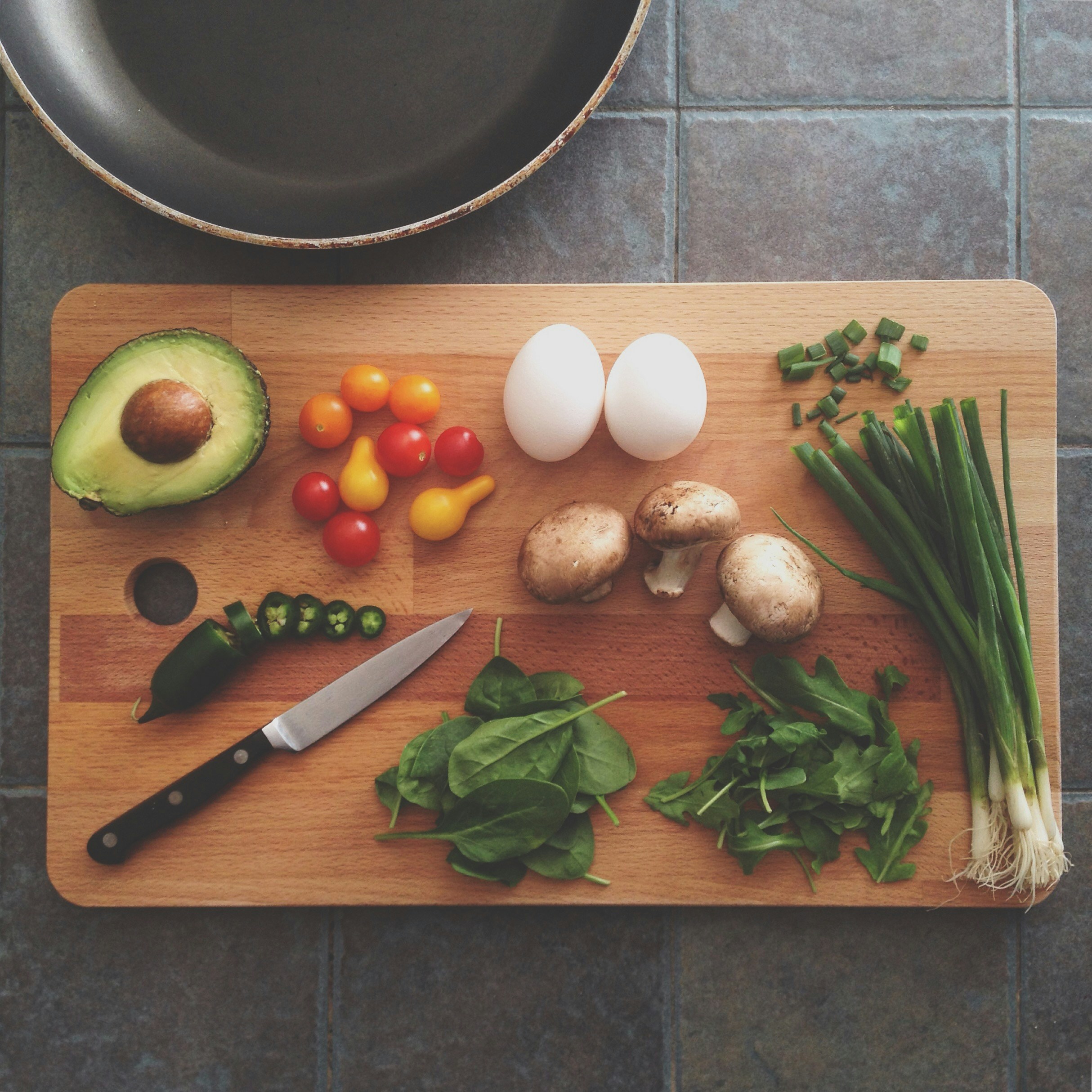 Vegetables and hard-boiled eggs arranged on a chopping board